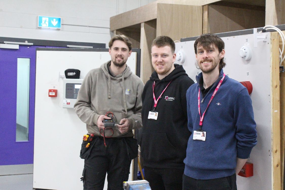 SERC Fire and Security apprentice Thomas Burns with teaching staff at the college's workshop on SERC Lisburn Campus